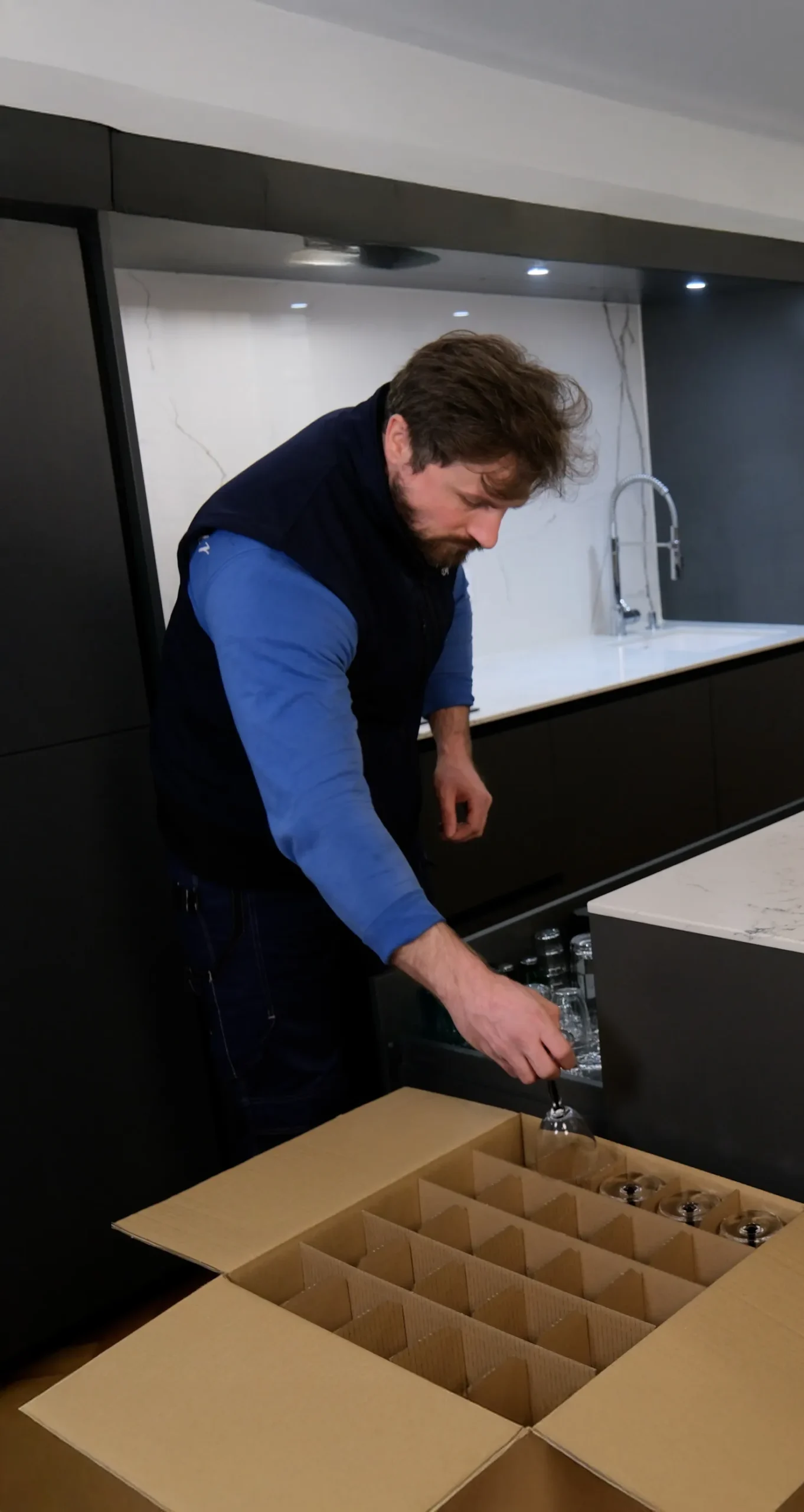 Déménageur 6ème Sens Déménagement emballant soigneusement des verres dans un carton compartimenté pour un transport sécurisé.