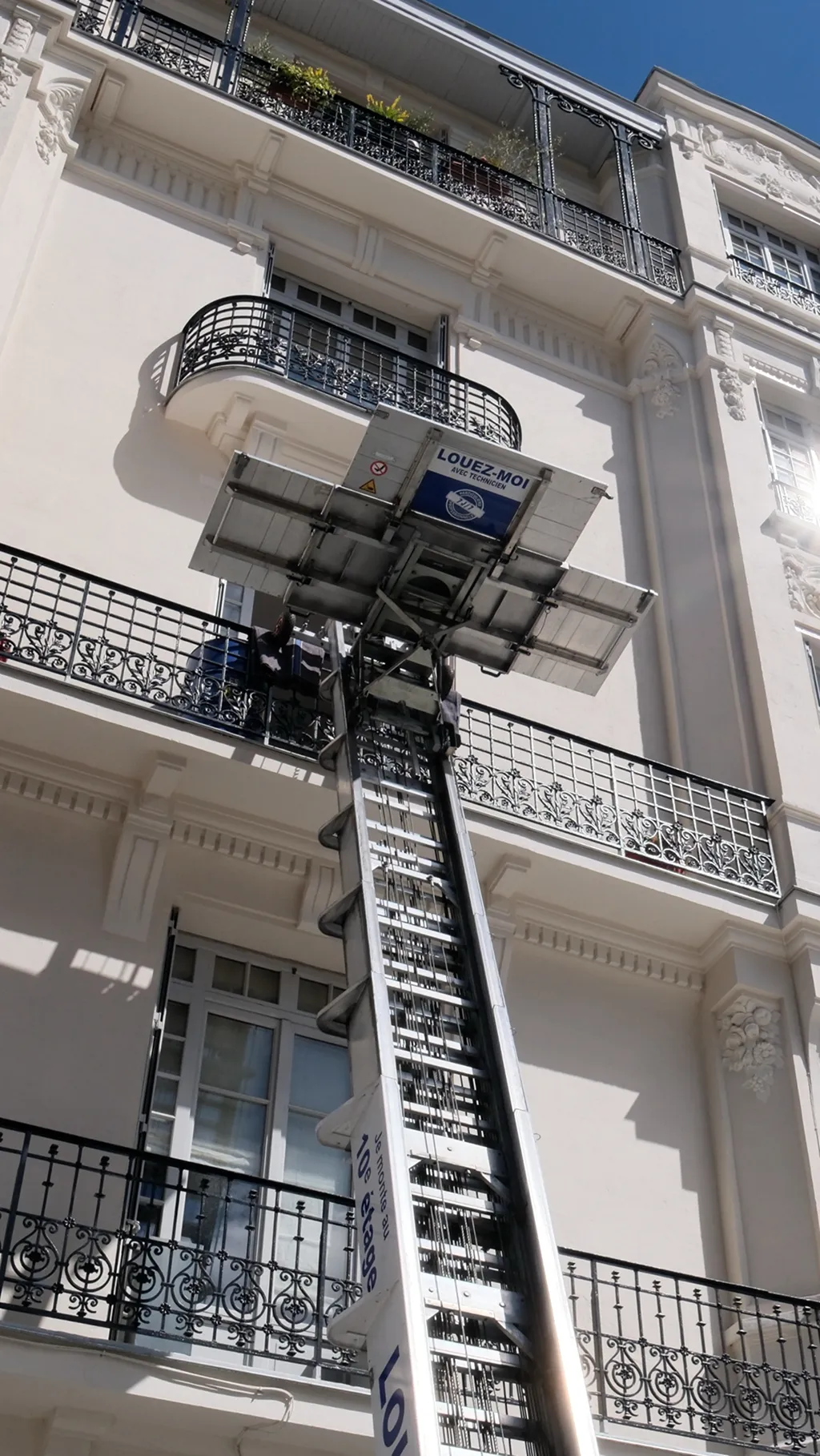 Monte-meubles en intervention sur la façade d'un immeuble pour faciliter un déménagement en étage avec 6ème Sens Déménagement.