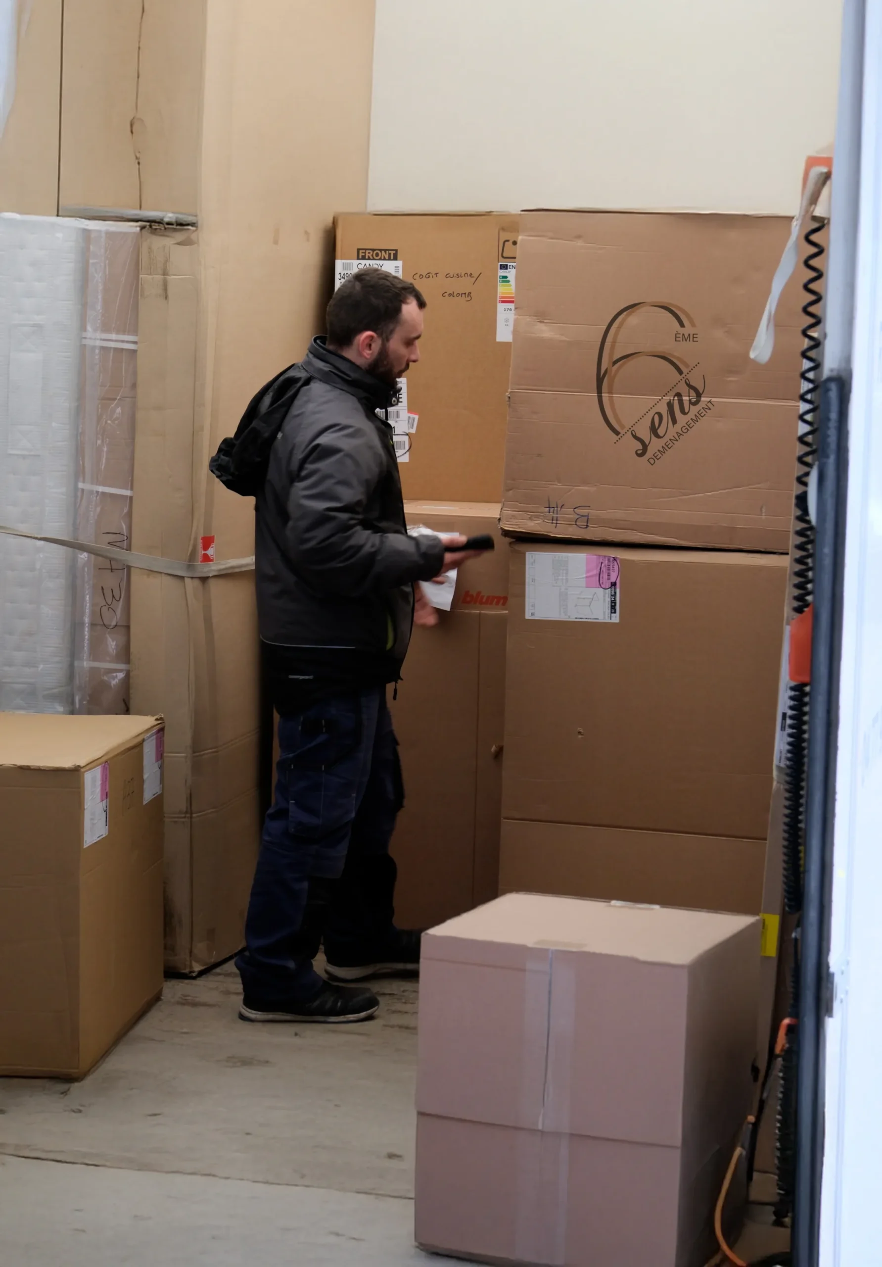 Déménageur de 6ème Sens Déménagement vérifiant les cartons avant le chargement pour un déménagement.