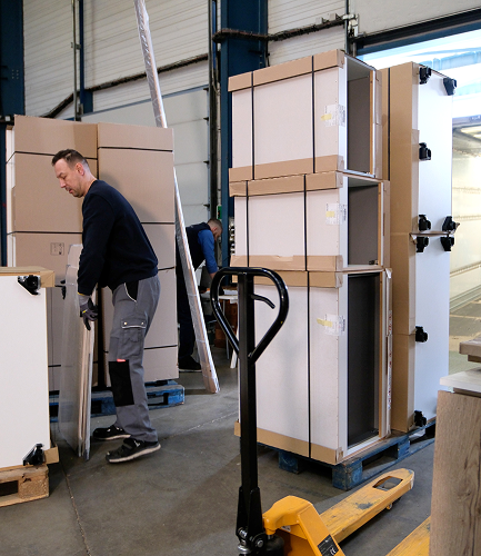 Déménageurs de 6ème Sens Déménagement manipulant du mobilier protégé dans un entrepôt logistique.